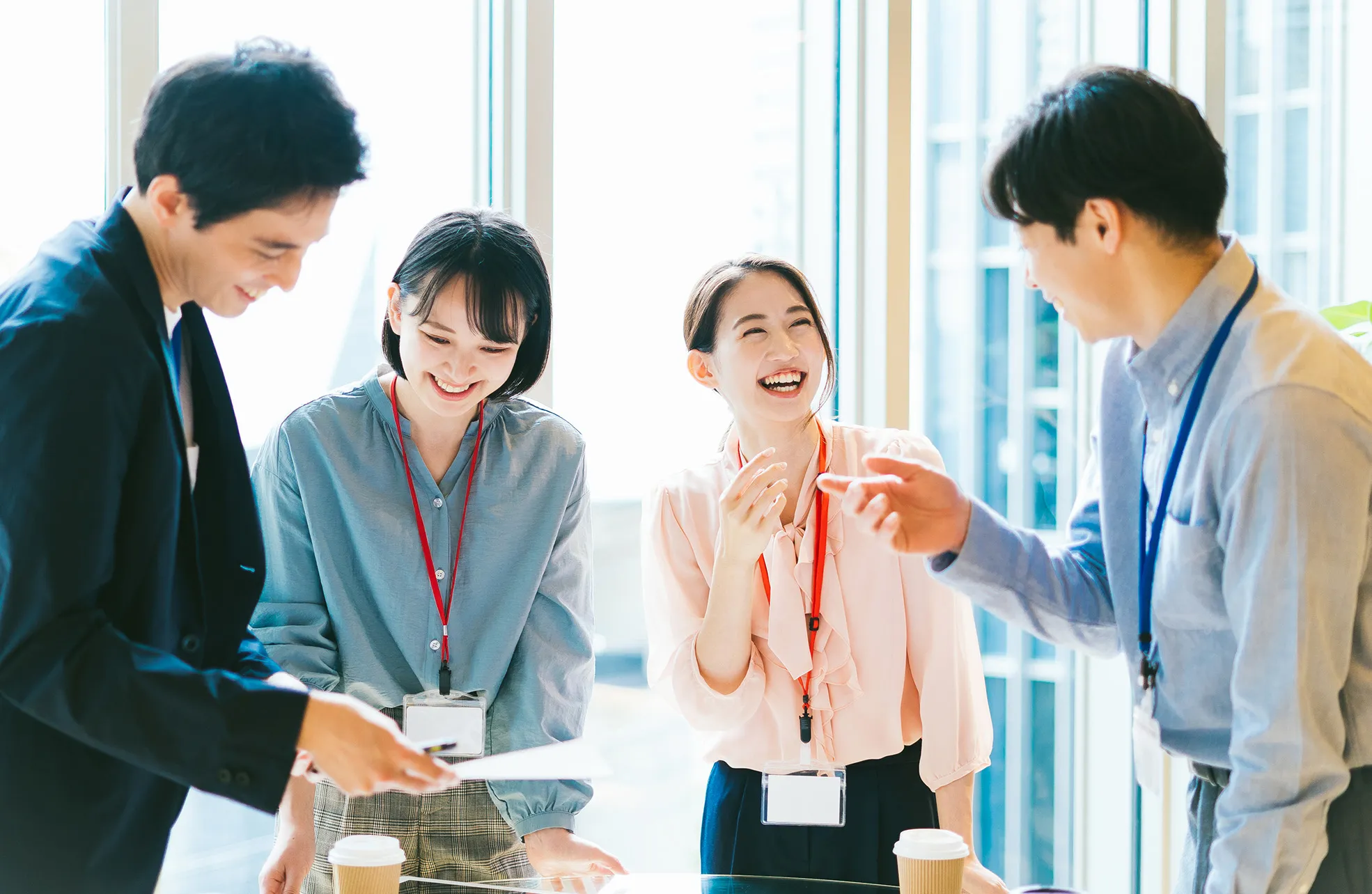 社員4名が窓際で歓談している
